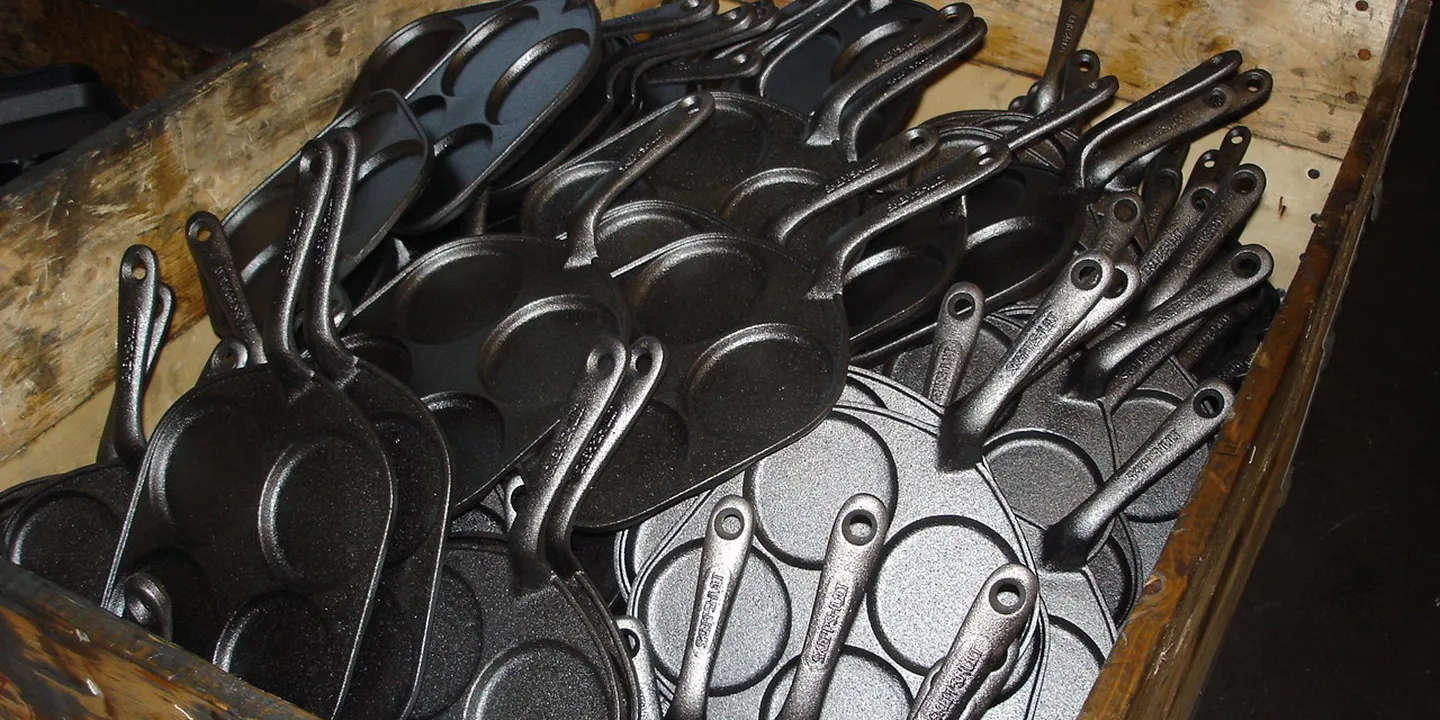 Caisse de poêles à blinis en fonte tout juste sorties du moule
